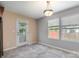 A bright dining area with gray walls, a door to a screened in porch, and two windows at 12829 Brandenburg Ln, Midland, NC 28107