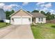 Charming single-story home featuring an attached two-car garage and well-maintained front lawn at 12829 Brandenburg Ln, Midland, NC 28107