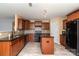 A spacious kitchen featuring wood cabinets, black appliances, and an island at 12829 Brandenburg Ln, Midland, NC 28107