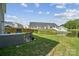 Backyard with view of community pond, fenced yard, patio set, and adjacent homes at 1311 Rowan Ln, Monroe, NC 28110