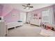 Delightful bedroom is adorned with pastel walls, large windows, and playful decor at 1311 Rowan Ln, Monroe, NC 28110