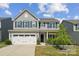 Charming two-story home with blue shutters, a white garage door, and a well-manicured front yard at 1311 Rowan Ln, Monroe, NC 28110
