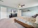 Well-lit main bedroom boasts large windows, ceiling fan, and neutral carpet at 1311 Rowan Ln, Monroe, NC 28110