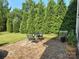 Private backyard with patio, green lawn, mature trees, and seating, perfect for outdoor relaxation at 1349 Bridgeford Nw Dr, Huntersville, NC 28078