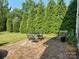 Inviting backyard patio with seating surrounded by lush green trees and manicured landscaping at 1349 Bridgeford Nw Dr, Huntersville, NC 28078