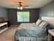 Comfortable bedroom featuring a ceiling fan, a serene window view, and soft, inviting bedding at 1349 Bridgeford Nw Dr, Huntersville, NC 28078