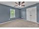 Cozy bedroom with a ceiling fan, window, and closet with double doors at 1349 Bridgeford Nw Dr, Huntersville, NC 28078