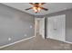 Carpeted bedroom with neutral gray walls, fan, walk-in closet and access to ensuite bathroom at 1349 Bridgeford Nw Dr, Huntersville, NC 28078