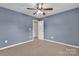 A carpeted bedroom with a ceiling fan and an open doorway at 1349 Bridgeford Nw Dr, Huntersville, NC 28078