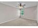 Bedroom featuring neutral colored walls and carpet, plus a ceiling fan and bright window at 1349 Bridgeford Nw Dr, Huntersville, NC 28078