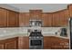 Close-up of kitchen showcasing stainless steel appliances, a gas range, and attractive granite countertops and backsplash at 1349 Bridgeford Nw Dr, Huntersville, NC 28078