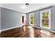 Serene bedroom with hardwood floors and large windows offering scenic views and plenty of natural light at 14402 Raynham Dr, Charlotte, NC 28262