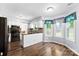 Bright kitchen with white cabinets, granite countertops, modern appliances, and an adjacent breakfast nook at 14402 Raynham Dr, Charlotte, NC 28262