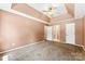 Spacious carpeted main bedroom featuring a trey ceiling, a ceiling fan, and a private entrance to an ensuite bathroom at 14402 Raynham Dr, Charlotte, NC 28262