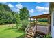 Inviting back porch with wooden railings offers a view of the lush backyard and green lawn at 1532 Buffalo Shoals Rd, Claremont, NC 28610