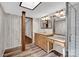 Bright bathroom features double vanity, wood-look floors, and skylight allowing for ample natural light at 1532 Buffalo Shoals Rd, Claremont, NC 28610