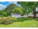 Exterior view of the detached garage, set amongst flowering bushes and lush greenery on the property at 1532 Buffalo Shoals Rd, Claremont, NC 28610