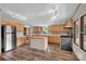 Well-lit kitchen featuring stainless steel appliances, wood cabinets, a center island, and sleek flooring at 1532 Buffalo Shoals Rd, Claremont, NC 28610