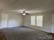 Well-lit living room featuring neutral walls, carpet, ceiling fan and two front windows at 1555 Moore Rd, York, SC 29745