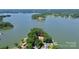 Breathtaking aerial view of a waterfront property with a sprawling lawn, private dock, and lush surrounding greenery at 160 Quail Hollow Dr, Kings Mountain, NC 28086
