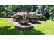 Well-maintained backyard with multi-level deck, lake views, mature trees and lush landscaping, perfect for outdoor activities at 160 Quail Hollow Dr, Kings Mountain, NC 28086