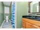 A full bathroom with a single vanity, toilet, mirror, and shower with blue curtain at 160 Quail Hollow Dr, Kings Mountain, NC 28086