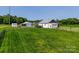 Scenic property showcasing a well-maintained home with a metal roof, detached garage, and expansive green space at 1640 Bear Poplar Rd, Cleveland, NC 27013