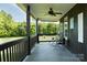 Relaxing covered porch area with wooden floors and decorative wall art, perfect for enjoying outdoor views at 1640 Bear Poplar Rd, Cleveland, NC 27013