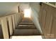 Staircase with wooden railing leads to upper level, bathed in natural light from the top of the stairs at 1640 Bear Poplar Rd, Cleveland, NC 27013