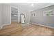 Unfinished basement featuring wood-look flooring, gray walls, and stairs to the main floor at 1709 Masonic Dr, Charlotte, NC 28205