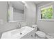 Bathroom with gray walls and white fixtures features a single sink and a toilet at 1709 Masonic Dr, Charlotte, NC 28205