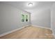 Bedroom features light gray walls, white trim, wood-look flooring, and a window view at 1709 Masonic Dr, Charlotte, NC 28205