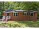 A cozy, single-story brick house with neat landscaping, complemented by blue shutters and a welcoming entrance at 1709 Masonic Dr, Charlotte, NC 28205
