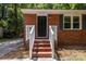 Close-up of the front porch, showcasing the brick steps, white railings, and a classic black front door at 1709 Masonic Dr, Charlotte, NC 28205