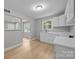 Bright kitchen features white cabinets, light countertops, a stainless sink, and wood-look flooring at 1709 Masonic Dr, Charlotte, NC 28205