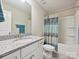 Well-lit bathroom with a granite vanity, white cabinets, tub-shower combo with a blue patterned shower curtain at 177 Yellow Birch Loop, Mooresville, NC 28117