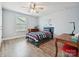 Cozy bedroom with wood floors, ceiling fan, window, and a desk, perfect for relaxation and study at 177 Yellow Birch Loop, Mooresville, NC 28117