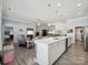 Open-concept kitchen island featuring a sink, pendant lights, and modern appliances at 177 Yellow Birch Loop, Mooresville, NC 28117