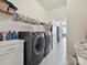 Functional laundry room with modern washer, dryer, storage shelves, and a convenient utility sink at 177 Yellow Birch Loop, Mooresville, NC 28117