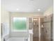 Bright bathroom featuring a shower with glass door and luxurious soaking tub at 2009 Trindle Vine Ln, Waxhaw, NC 28173