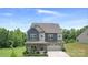 Inviting two-story home featuring a stone facade, blue accents, and a well-manicured front yard at 2009 Trindle Vine Ln, Waxhaw, NC 28173