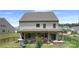 Rear exterior with covered patio and outdoor dining, featuring a grill and landscaped yard at 2009 Trindle Vine Ln, Waxhaw, NC 28173