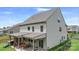 Two story rear exterior with covered patio and outdoor dining, featuring a grill and landscaped yard at 2009 Trindle Vine Ln, Waxhaw, NC 28173