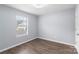 Bright bedroom with wood-look flooring, a window for natural light, and neutral wall paint at 2045 Pin Oak Pl, Cramerton, NC 28032