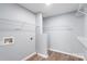 Bright laundry room with wood-look floors and wire shelving for organized storage at 2045 Pin Oak Pl, Cramerton, NC 28032