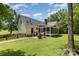 Backyard view featuring a screened porch, patio, grill and large grassy lawn at 2159 Quiet Cove Ln, Stanfield, NC 28163