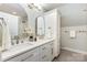 Bright bathroom featuring double sinks, white cabinets, and tile floors at 2159 Quiet Cove Ln, Stanfield, NC 28163
