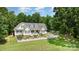 Charming yellow home featuring a manicured lawn and a classic white picket fence at 2159 Quiet Cove Ln, Stanfield, NC 28163