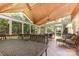 Spacious screened porch with wood ceiling, comfortable seating, and wooded views at 2159 Quiet Cove Ln, Stanfield, NC 28163