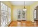 Bright breakfast nook with shuttered windows, hardwood floors and modern lighting fixture at 2321 Oberwood Dr, Charlotte, NC 28270